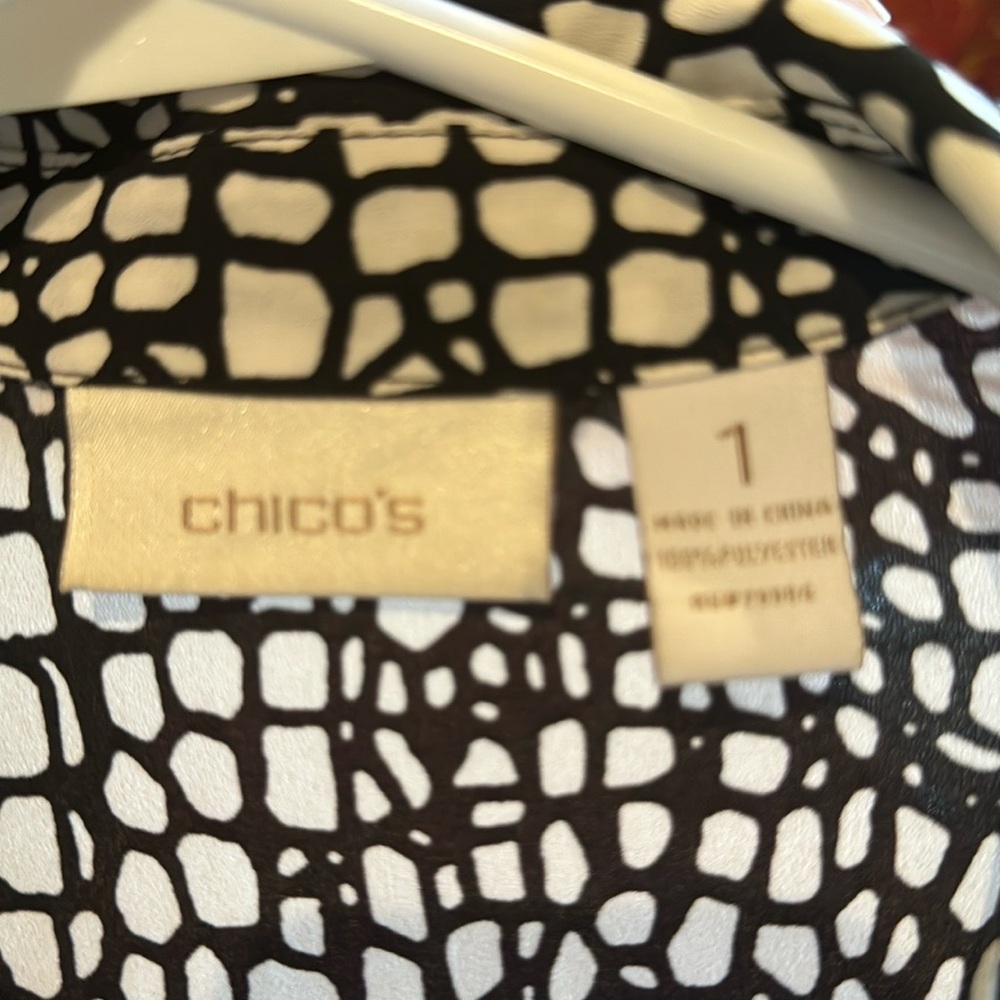 Chico’s size one, 100% polyester, long sleeve button down black and white shirt.